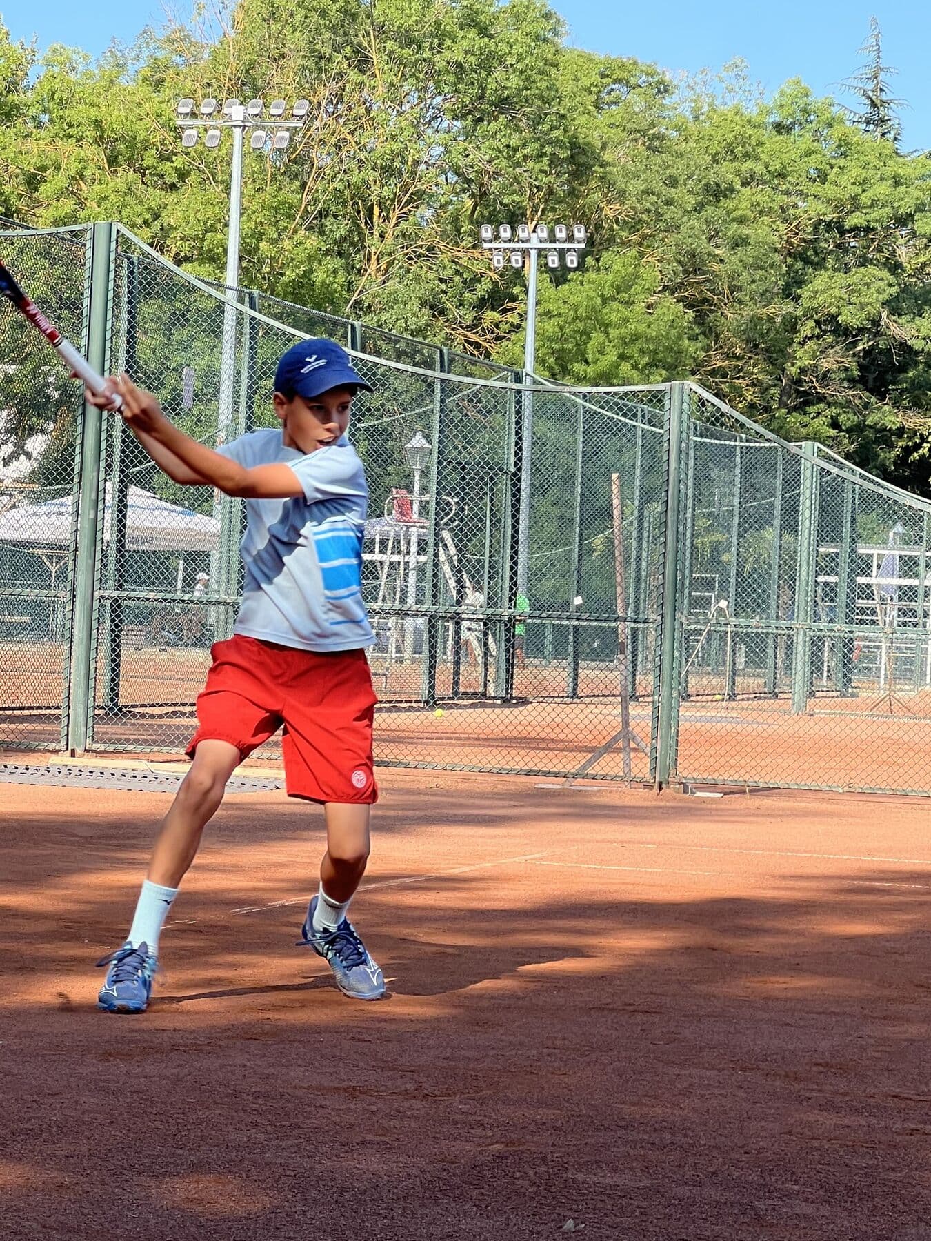 Ioan lovind un forehand pe terenul de zgură